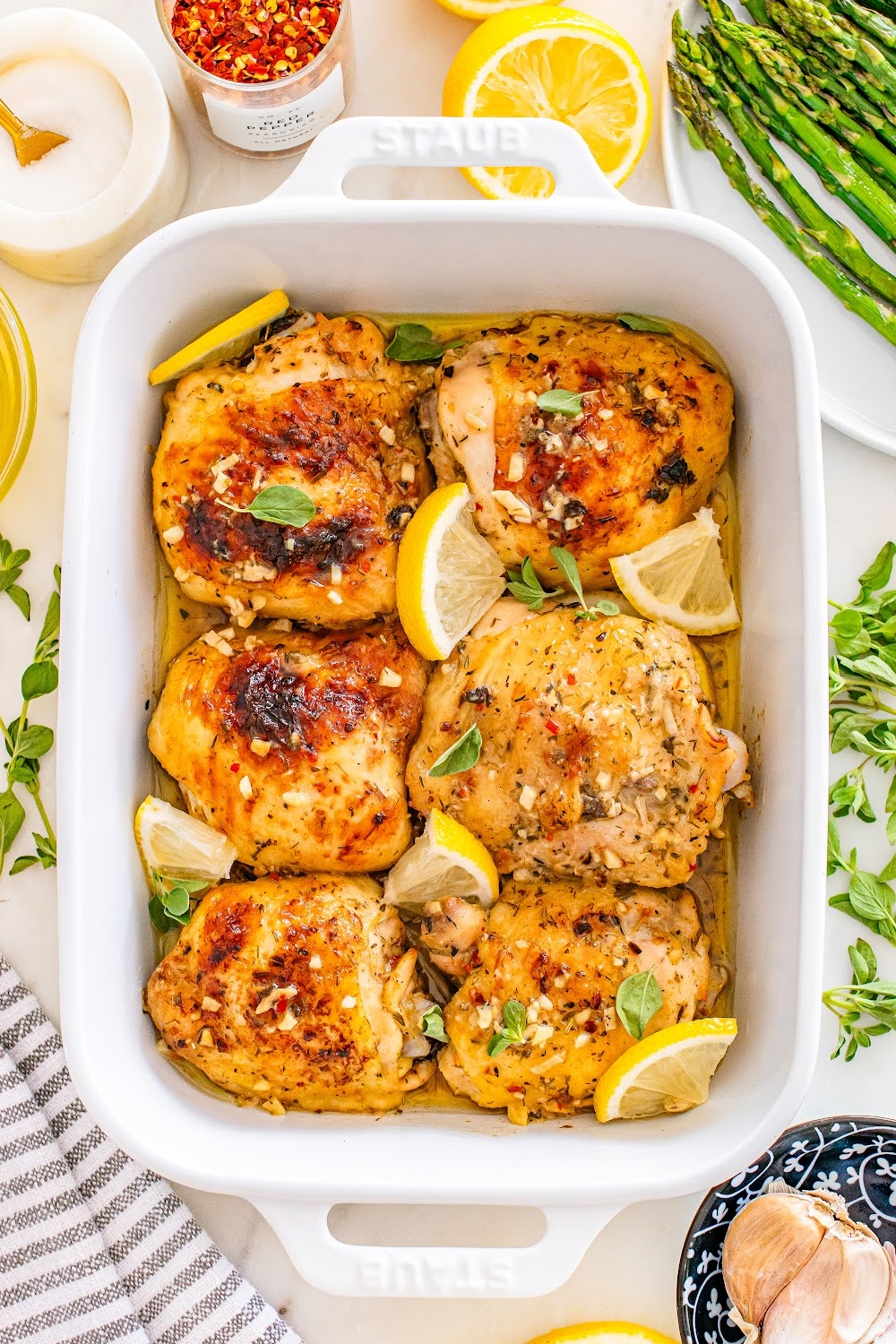 Greek Lemon Chicken Thighs baked in a white casserole dish.