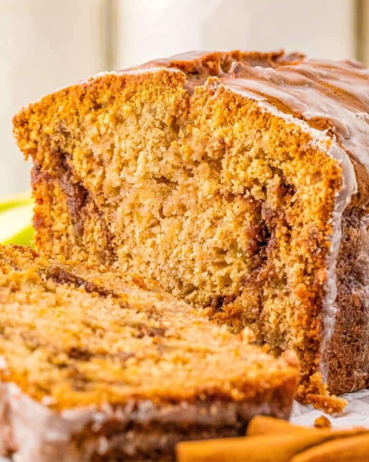 A sliced loaf of Apple Cinnamon bread with glaze.
